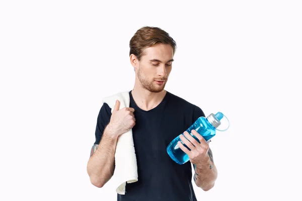 Hombre en camiseta negra con botella de agua en la mano y toalla en hombro vista recortada — Foto de Stock