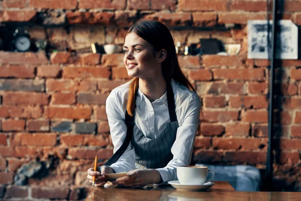 桌旁穿着咖啡店制服的女服务员 — 图库照片