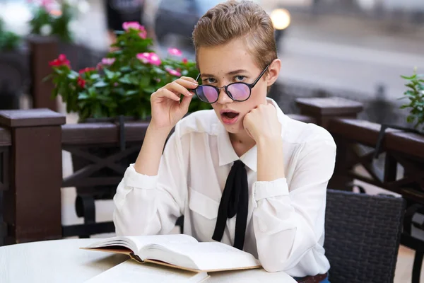 Femme avec des lunettes portrait gros plan fleurs dans le fond blanc chemise cravate livre modèle — Photo
