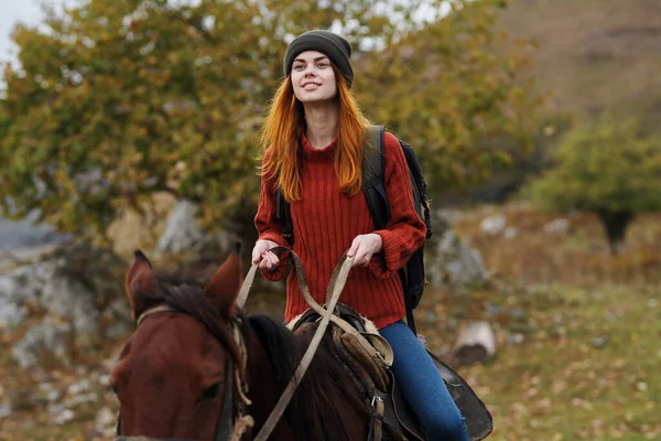 Dağlarda at süren bir kadın yürüyüşçü. Taze hava eğlencesi. — Stok fotoğraf