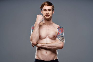 Kollarında dövmeleri olan, gövdesi şişmiş, vücut geliştiren bir adam.