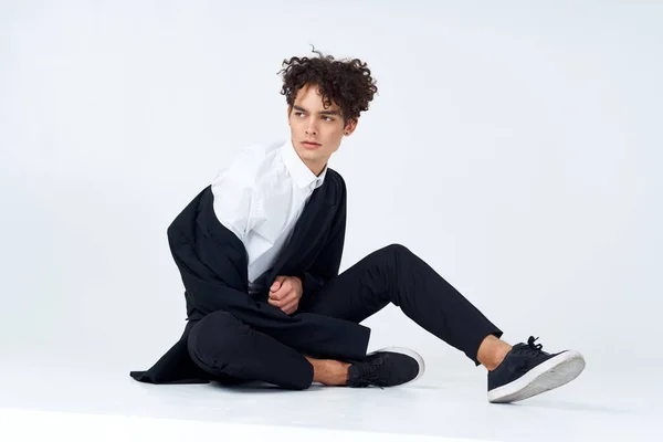 Cara sentado no chão cabelo encaracolado terno estilo moderno — Fotografia de Stock