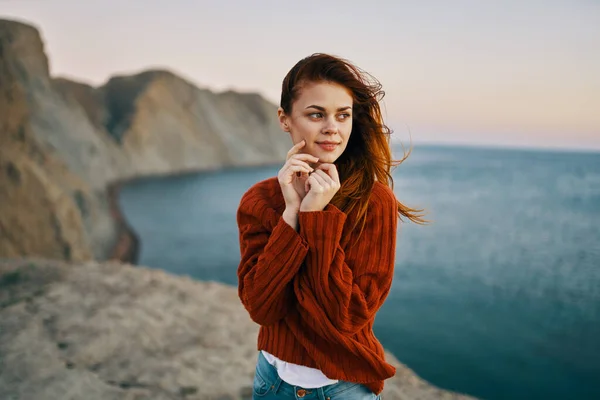 Femme en pull rouge dans les montagnes près de la mer modèle de tourisme de voyage — Photo