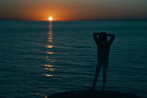 Femme près de la mer au coucher du soleil silhouette sombre et modèle de plage — Photo