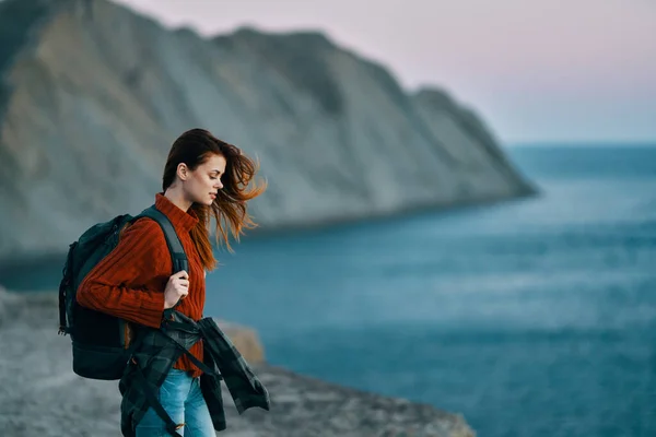 Viaggiatore nella natura in montagna in un maglione con uno zaino sul retro — Foto Stock