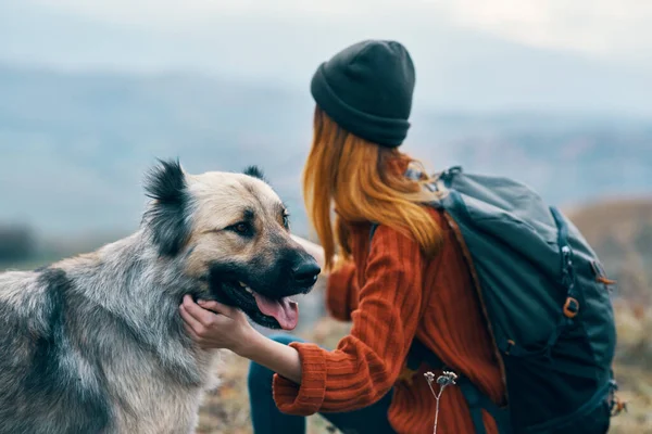 Vrouw wandelaar in de bergen buiten naast de hond reizen — Stockfoto