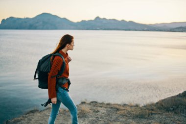 Sırtına kilitlenen güzel bir kadın. Turizm, dağları aşar. Gün batımı modeli.