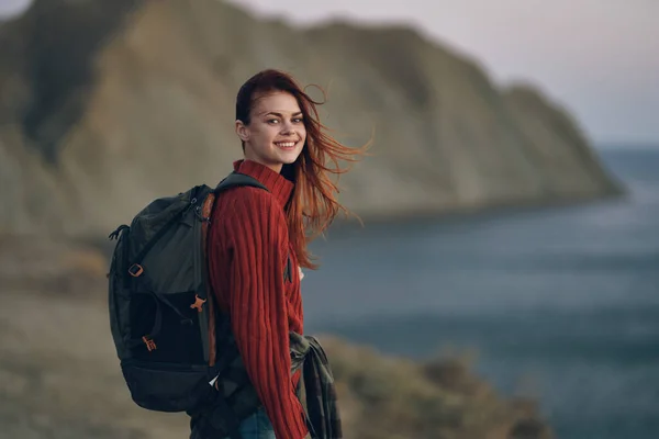 Donna con zaino modello maglione rosso e montagne oceano natura — Foto Stock