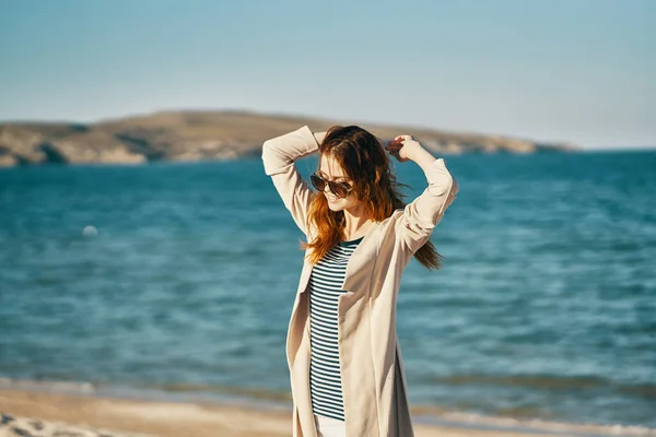 Mujer con las manos levantadas en la playa olas montañas aire fresco — Foto de Stock