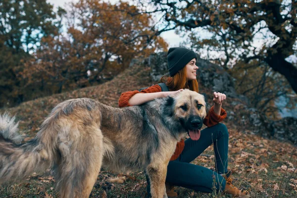 Woman with backpack beside dog friendship nature travel vacation — Stock Photo, Image