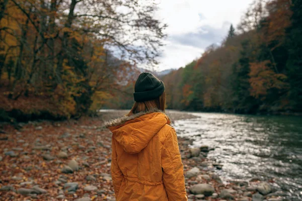 Vrouw wandelen langs de rivier gevallen bladeren herfst reizen — Stockfoto
