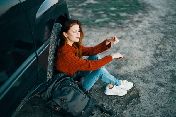 Mujer en las montañas en la arena con una mochila cerca de la vista superior del coche —  Fotos de Stock