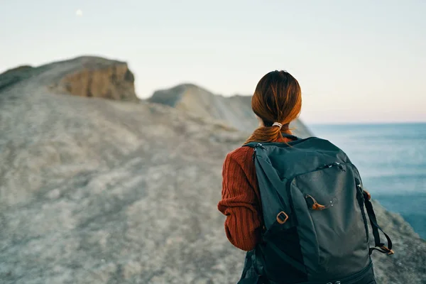 Bella escursionista donna con uno zaino sulla schiena in montagna vicino al modello paesaggio marino — Foto Stock