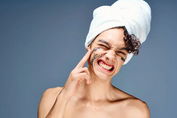 Парень с полотенцем на голове крем для лица уход за кожей — стоковое фото