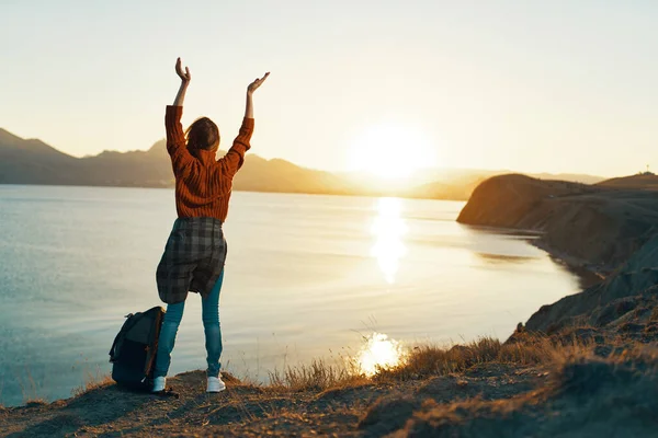 Woman tourist with a backpack looks at the sunset Horizon nature landscape — Stock Photo, Image