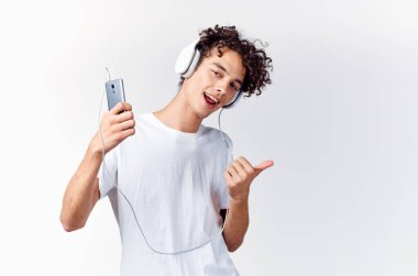 Kulaklıklı komik, kıvırcık adam müzik dinliyor, duygusal eğlence dinliyor.