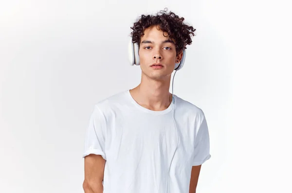 Teenager tričko a ve sluchátkách na lehkém pozadí nový technologický model — Stock fotografie