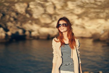 Kadın dağlarda seyahat ediyor. Yaz gözlükleriyle nehir kenarındaki turizm modeli.