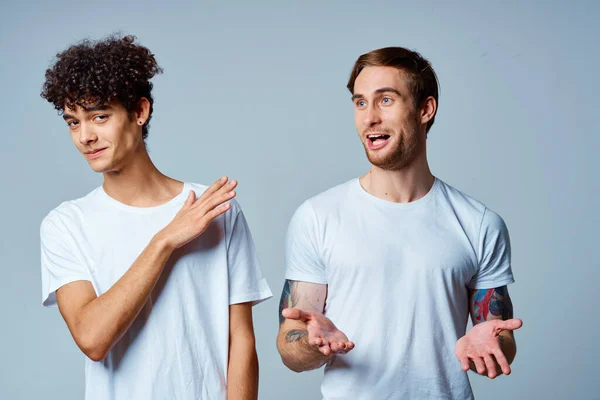 Dos hombres con camisetas blancas están de pie junto a las emociones de amistad — Foto de Stock