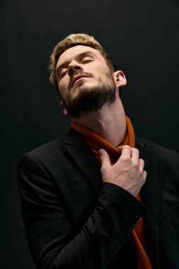 Koyu renk elbiseli ve turuncu kazaklı sarışın adam...