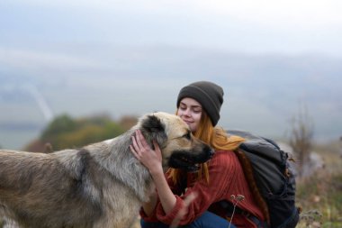 Kadın turist köpek kucaklıyor doğa seyahat arkadaşlığı