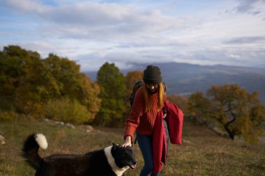 Kadınlar doğada köpeğin yanında yürürken dağlar seyahat eder.