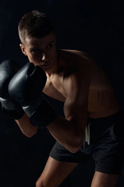 검은 배경에 몸을 굽히고 장갑을 끼고 있는 권투 선수 — 스톡 사진
