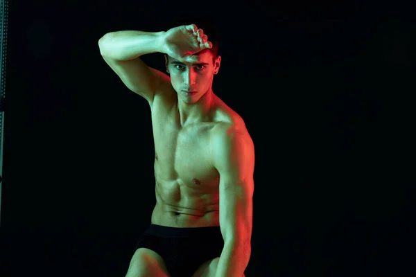 Sportig man med pumpade muskler på magen poserar på isolerad bakgrund beskärd vy — Stockfoto