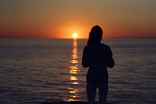 Silhouette einer Frau mit Kamera bei Sonnenuntergang in der Nähe der Meeresstrandlandschaft — Stockfoto