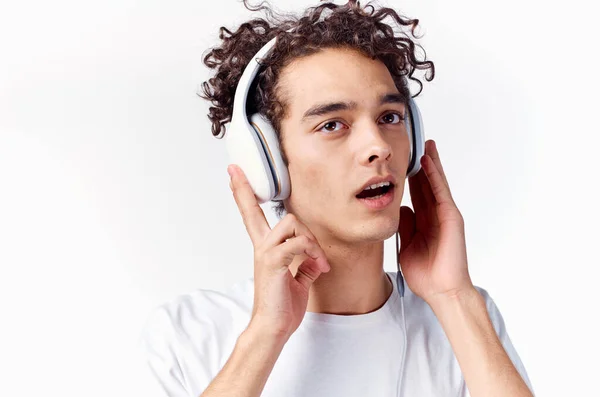 Kulaklıklı, beyaz tişörtlü bir adam müzik dinliyor. Keyif alıyor. — Stok fotoğraf