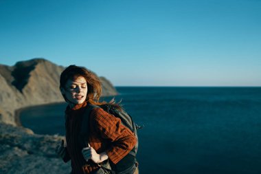 Sırt çantalı bir kadın. Dağlarda yürüyor. Temiz hava.