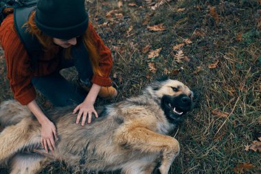 Köpeğin yanındaki sırt çantalı turist eğleniyor.