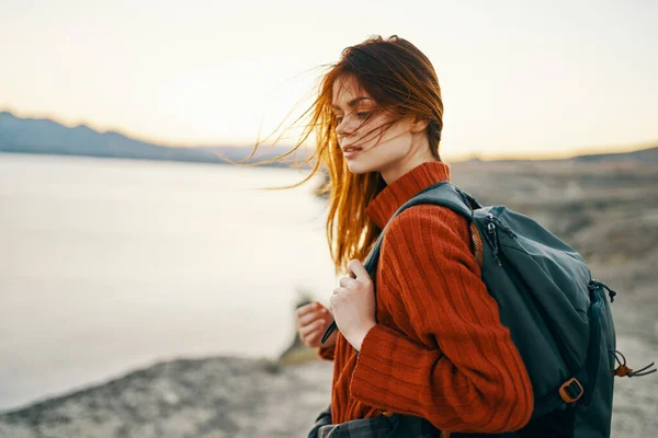 Donna turista in maglione con zaino in autunno in montagna vicino al mare — Foto Stock