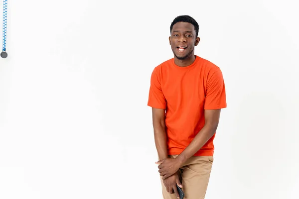 Vista cortada de um homem africano alegre com um telefone celular em um fundo leve rindo — Fotografia de Stock