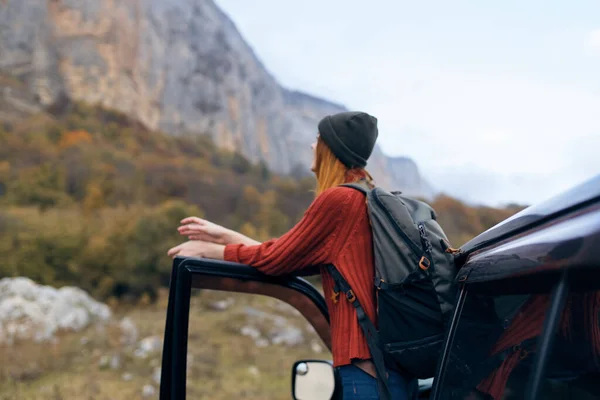 Mujer viaja en las montañas cerca del viaje en coche — Foto de Stock