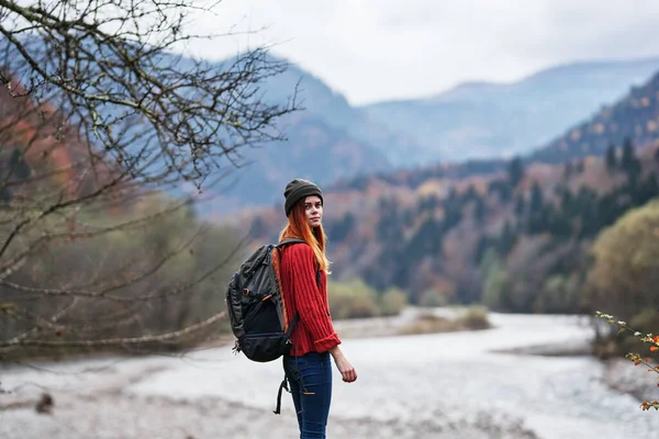 Femme heureuse avec sac à dos repos dans les montagnes près de la rivière sur la nature automne paysage air frais — Photo