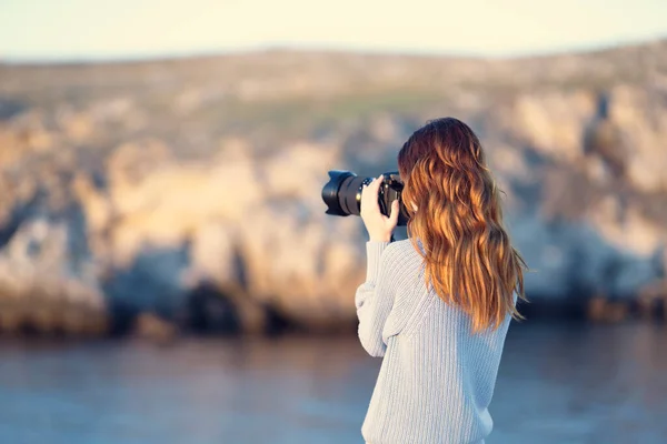 Cheerful woman photographer with a camera in her hands in the nature sun — Stock Photo, Image