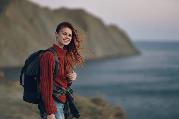 Frau mit Rucksack roter Pullover Modell und Berge Meer Natur — Stockfoto