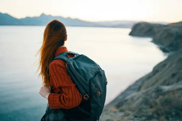 Nő piros pulóver hátizsák és utazási turizmus tengeri hegyek — Stock Fotó