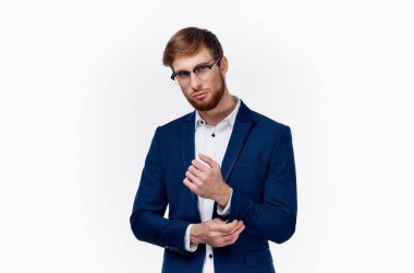 Klasik takım elbiseli sarışın adam ceketinin kollarını kırpıştırıyor.