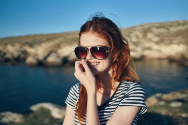 Dağlarda açık havada gözlük takan bir kadının portresi. Turizm temiz su gölü nehrinde seyahat ediyor.