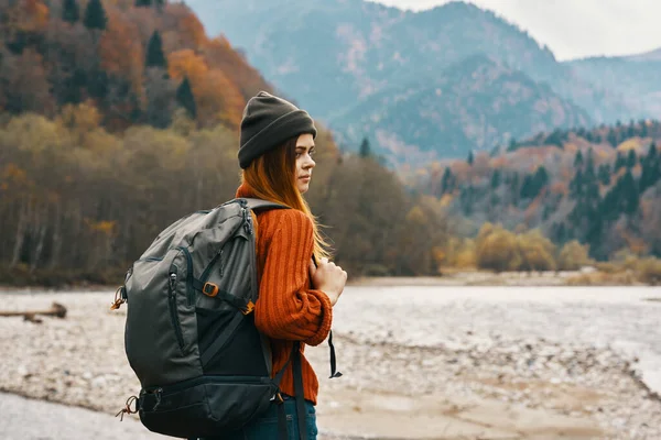 Mulher feliz na floresta de outono nas montanhas ao ar livre com uma mochila em suas costas turismo de viagens — Fotografia de Stock