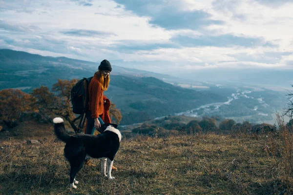 Mujer con mochila en la naturaleza al lado de perro paseo montaña paisaje —  Fotos de Stock