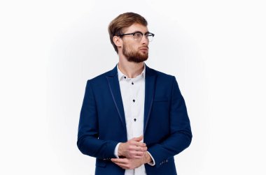 Mavi ceketli, gözlüklü, açık renk gömlekli bir iş adamı.