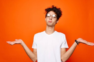 Beyaz tişörtlü, kıvırcık saçlı bir adam.