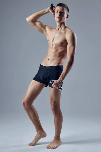 Sporty man muscular torso black panties dumbbells in hand — Stok Foto