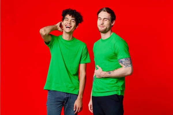 Due amici in t-shirt verdi tengono le loro emozioni pancia — Foto Stock