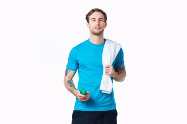 Elinde dambıllar, omuzlarında havluyla egzersiz yapan sportif bir adam.