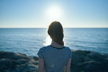 Turizm seyahati dağları manzaralı kadın deniz batımının yanındaki plajda