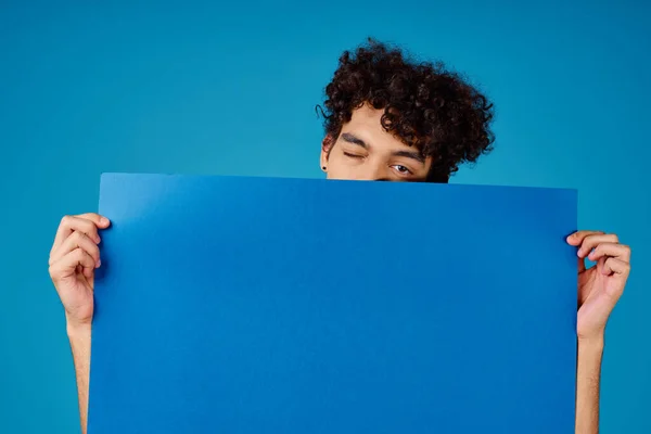 곱슬곱슬 한 파란색 흉내 내기 포스터 스튜디오에 있는 쾌활 한 남자 — 스톡 사진
